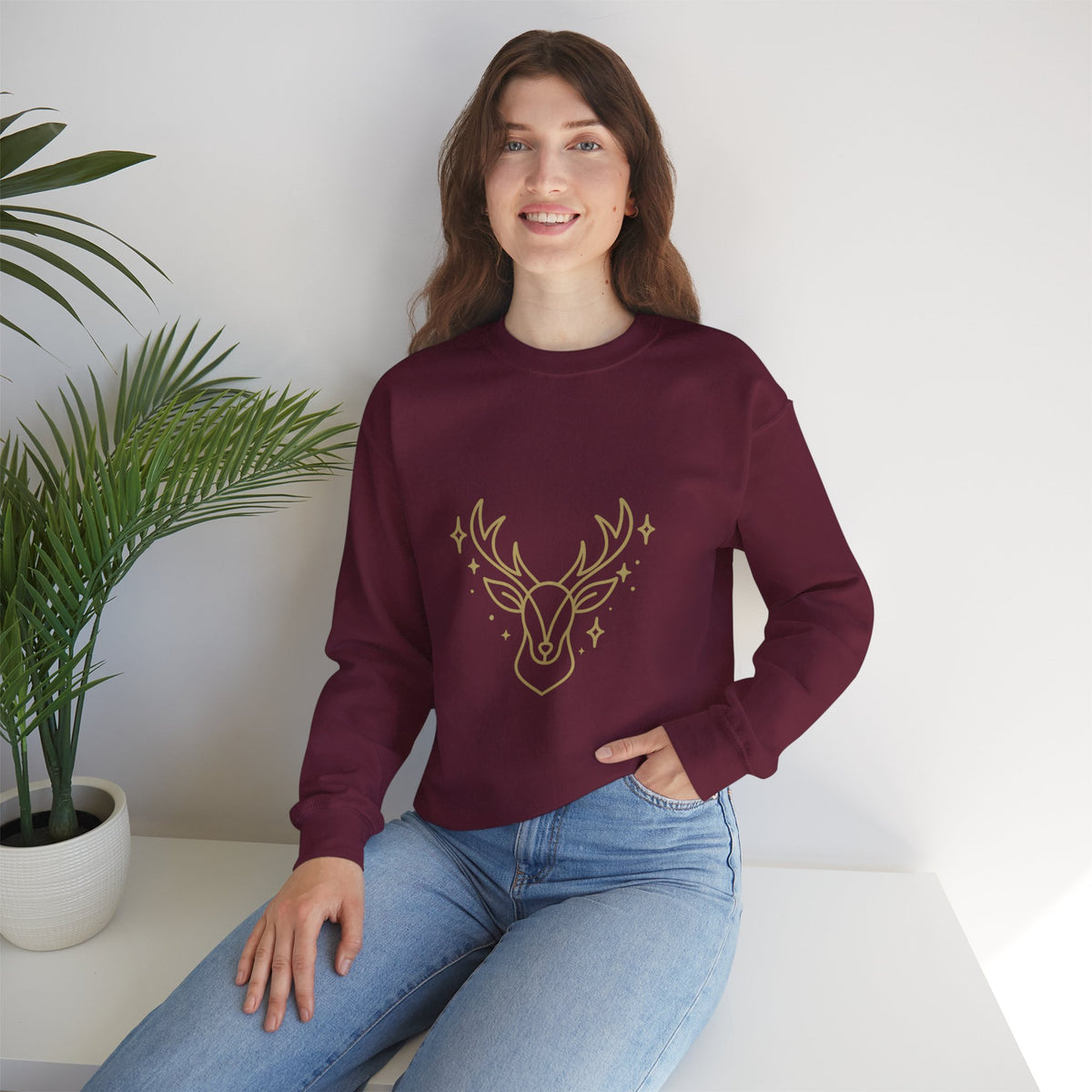 Model wearing a maroon minimalist gold-colored reindeer sweatshirt