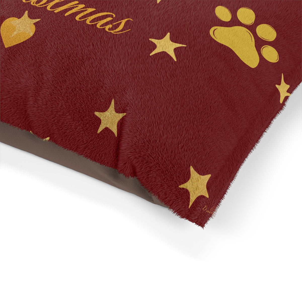 Close-up of Christmas pet bed fleece fabric and gold-colored paw artwork