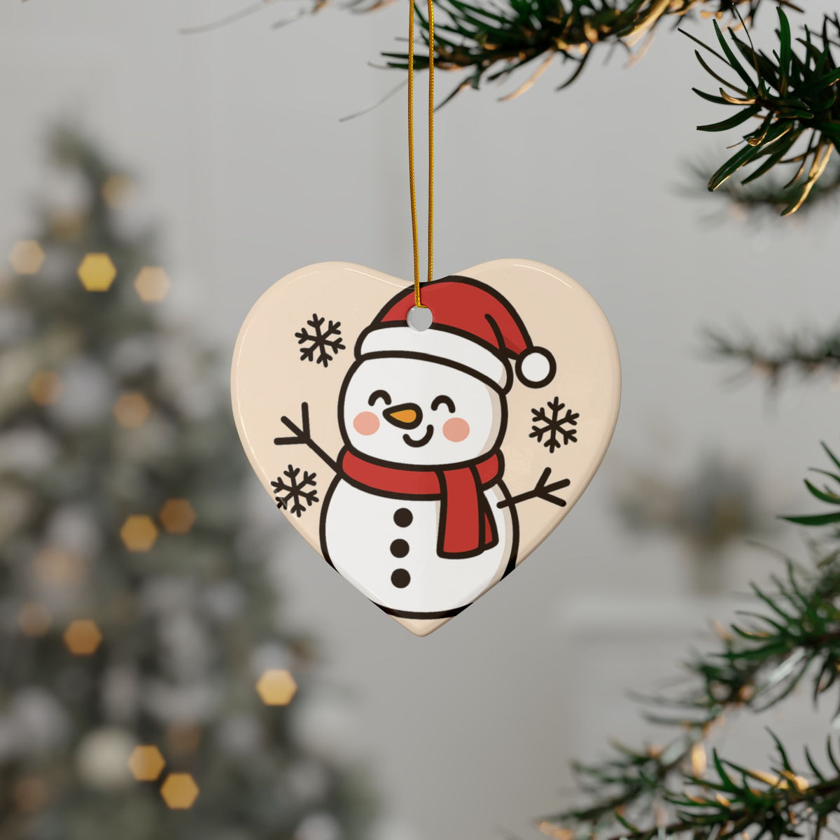 Heart-shaped smiling snowman ornament hanging on a Christmas tree