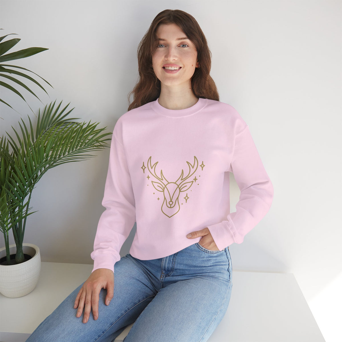 Model wearing a light pink minimalist gold-colored reindeer sweatshirt