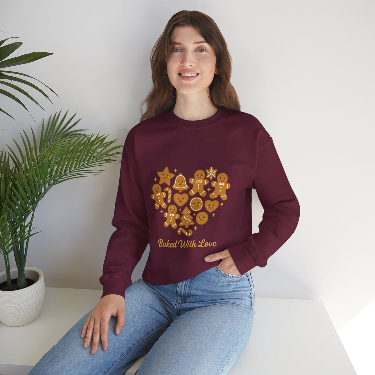 Model wearing a maroon Baked With Love gingerbread heart sweatshirt