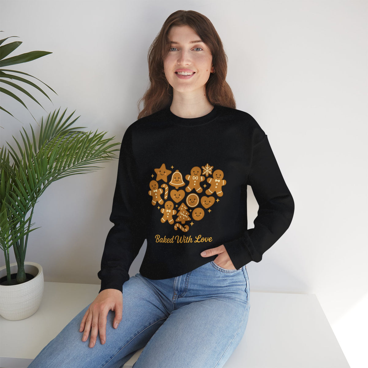 Model wearing a black Baked With Love gingerbread heart sweatshirt