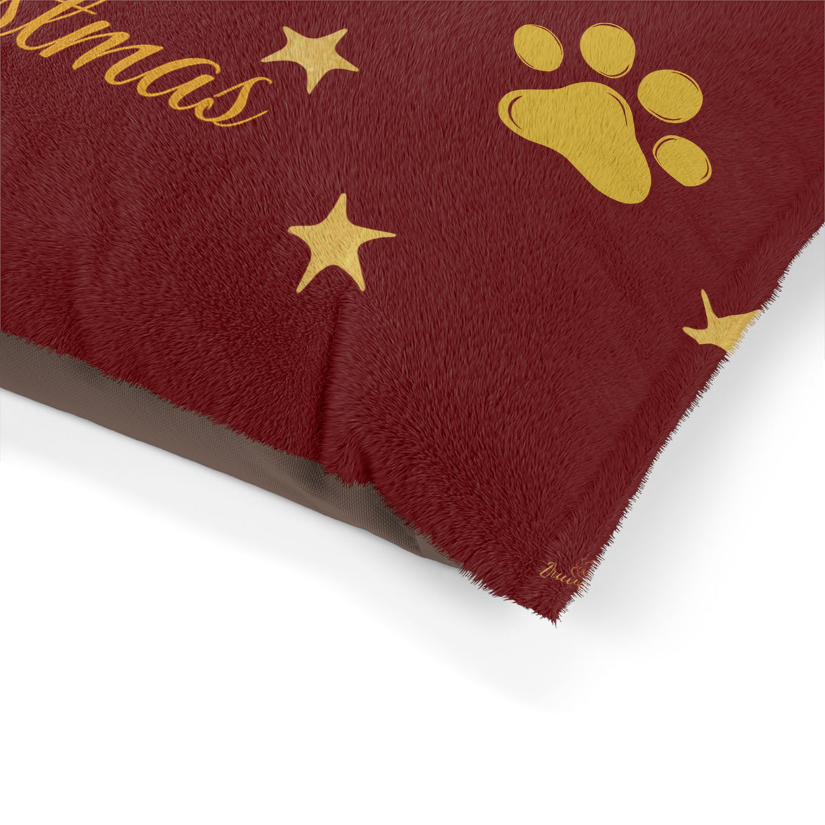 Close-up of gold-colored paw prints on red Christmas pet bed
