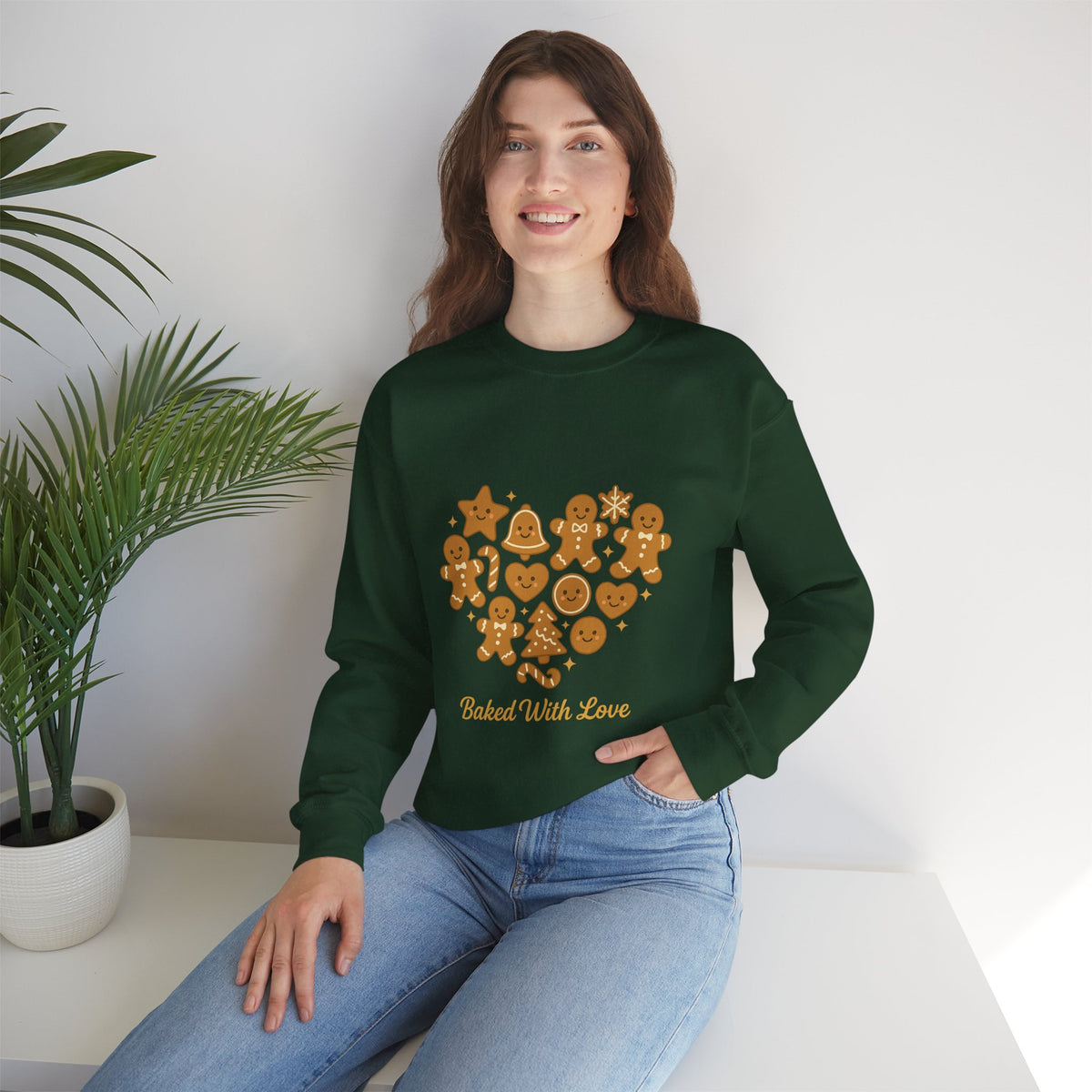 Model wearing a forest green Baked With Love gingerbread heart sweatshirt