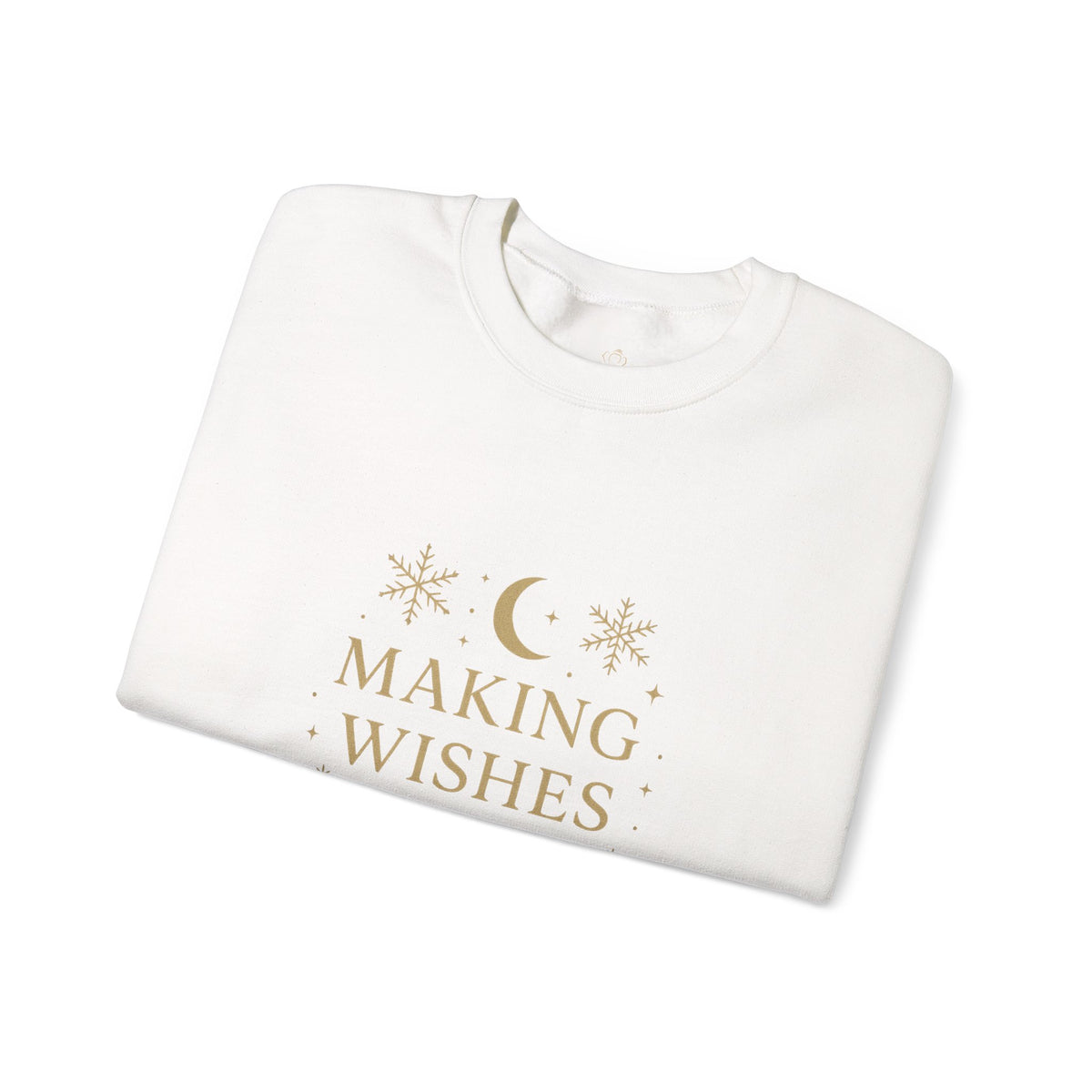 Folded white sweatshirt showing Making Wishes Come True moon and snowflake print