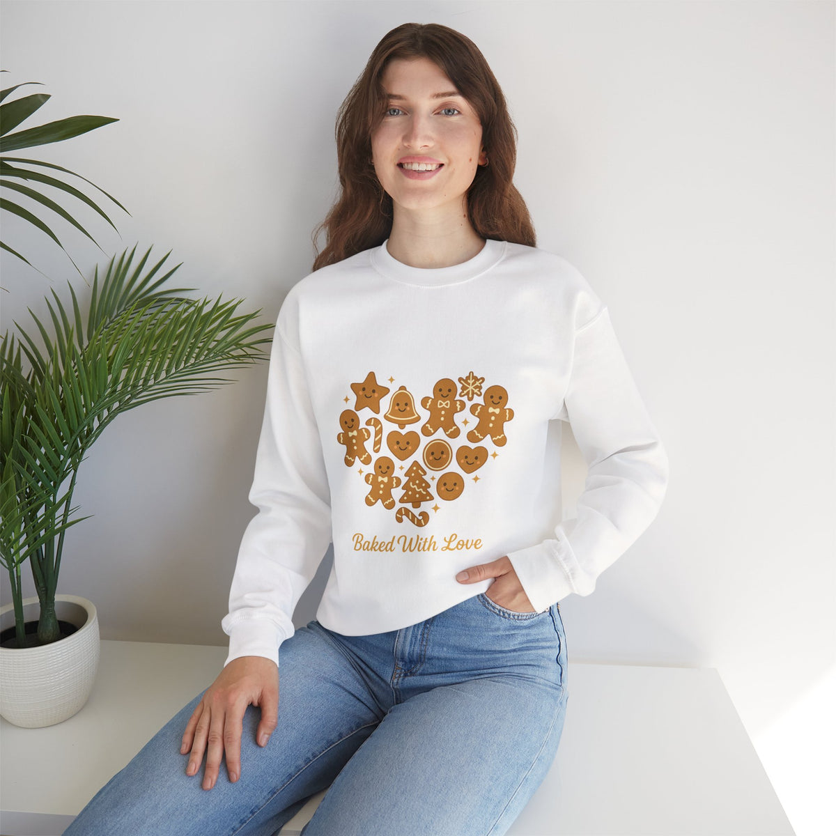 Model wearing a white Baked With Love gingerbread heart sweatshirt