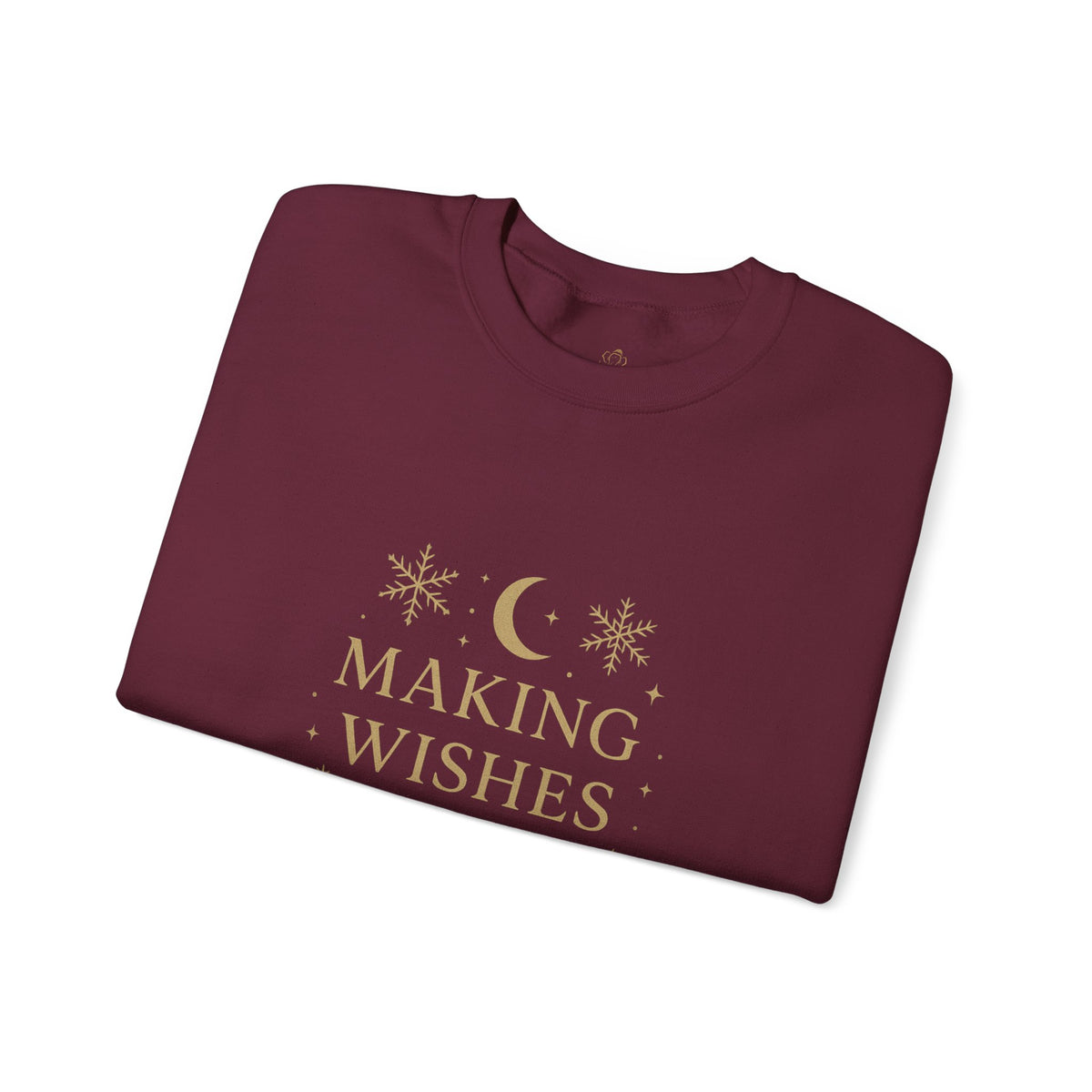 Folded maroon sweatshirt showing Making Wishes Come True moon and snowflake print