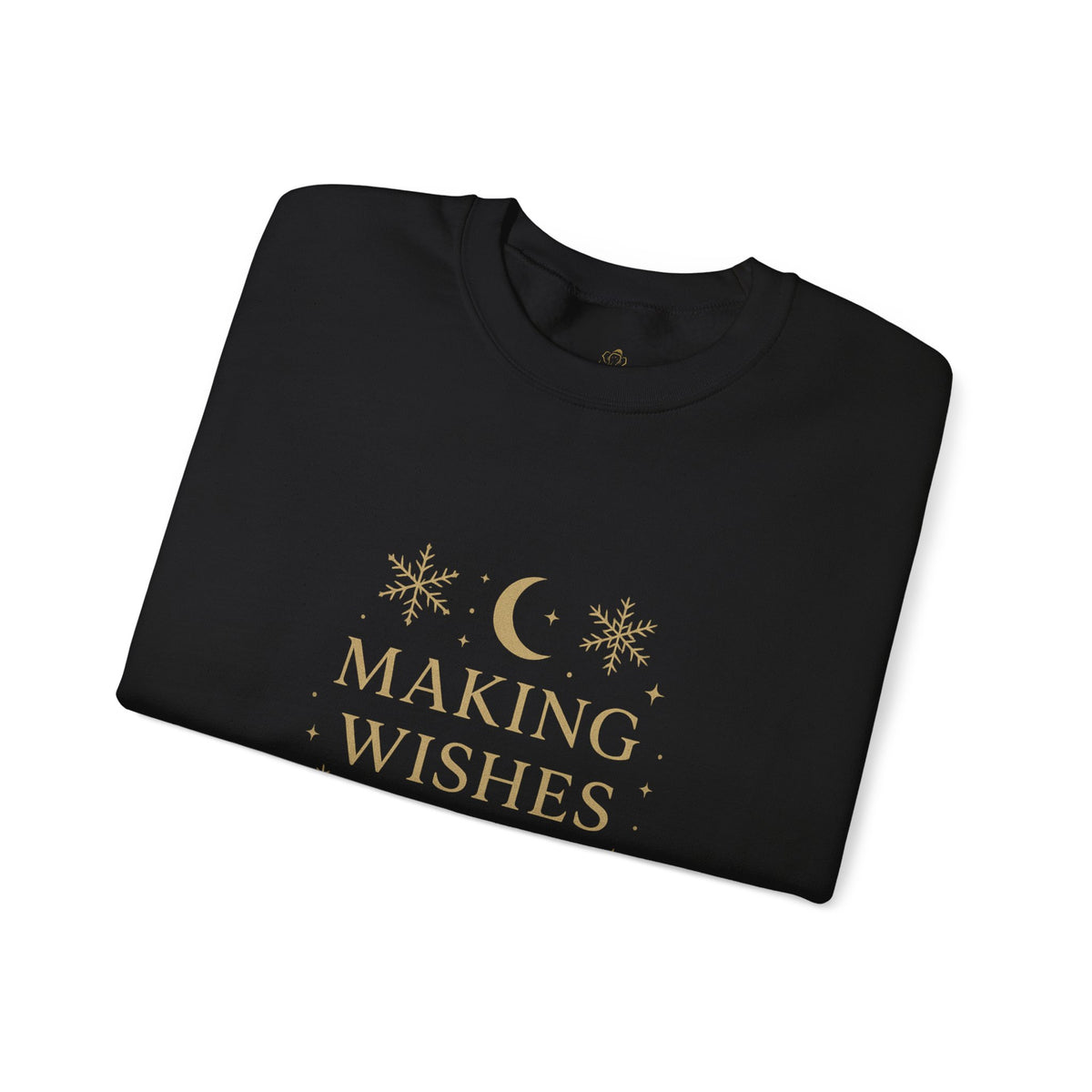 Folded black sweatshirt showing Making Wishes Come True moon and snowflake print