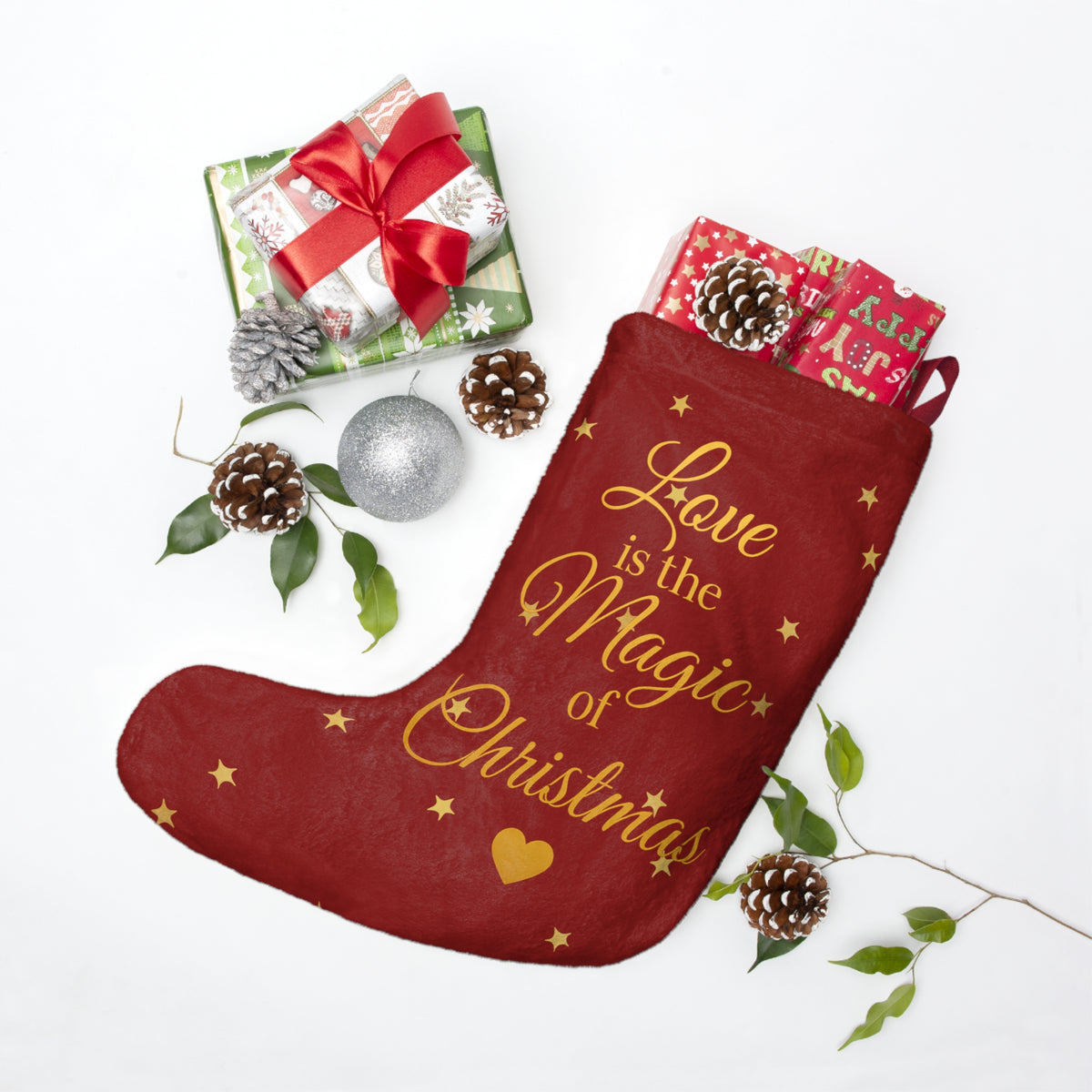 Red Christmas stocking displayed with wrapped gifts and festive greenery