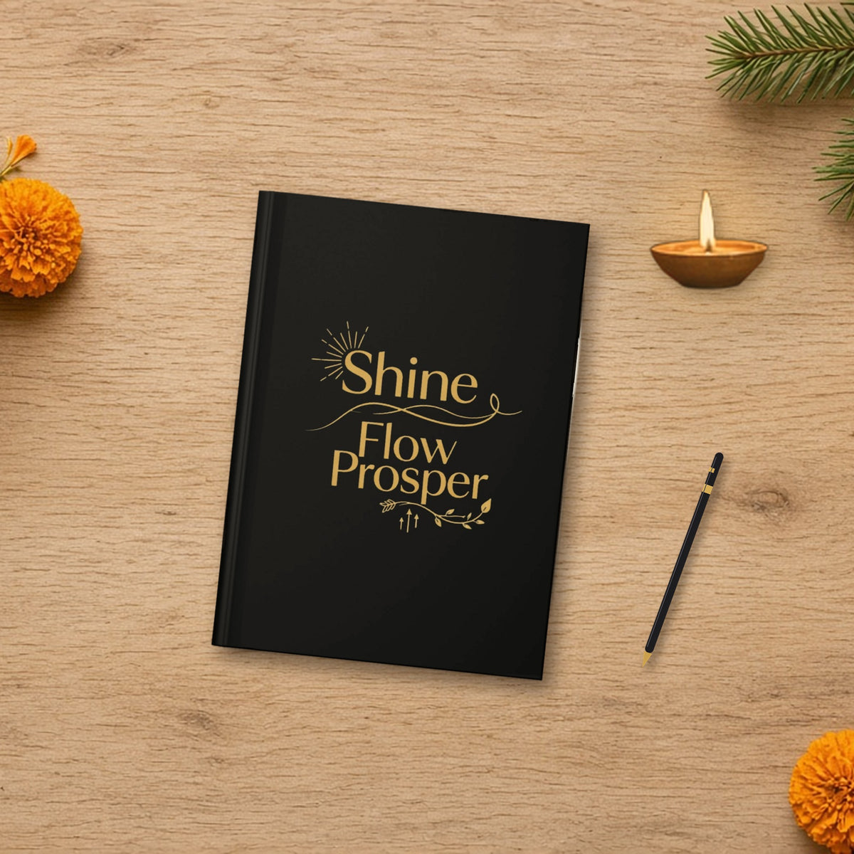 Shine Flow Prosper Luxe Manifestation Journal in a warm flat lay with a candle, pen and greenery