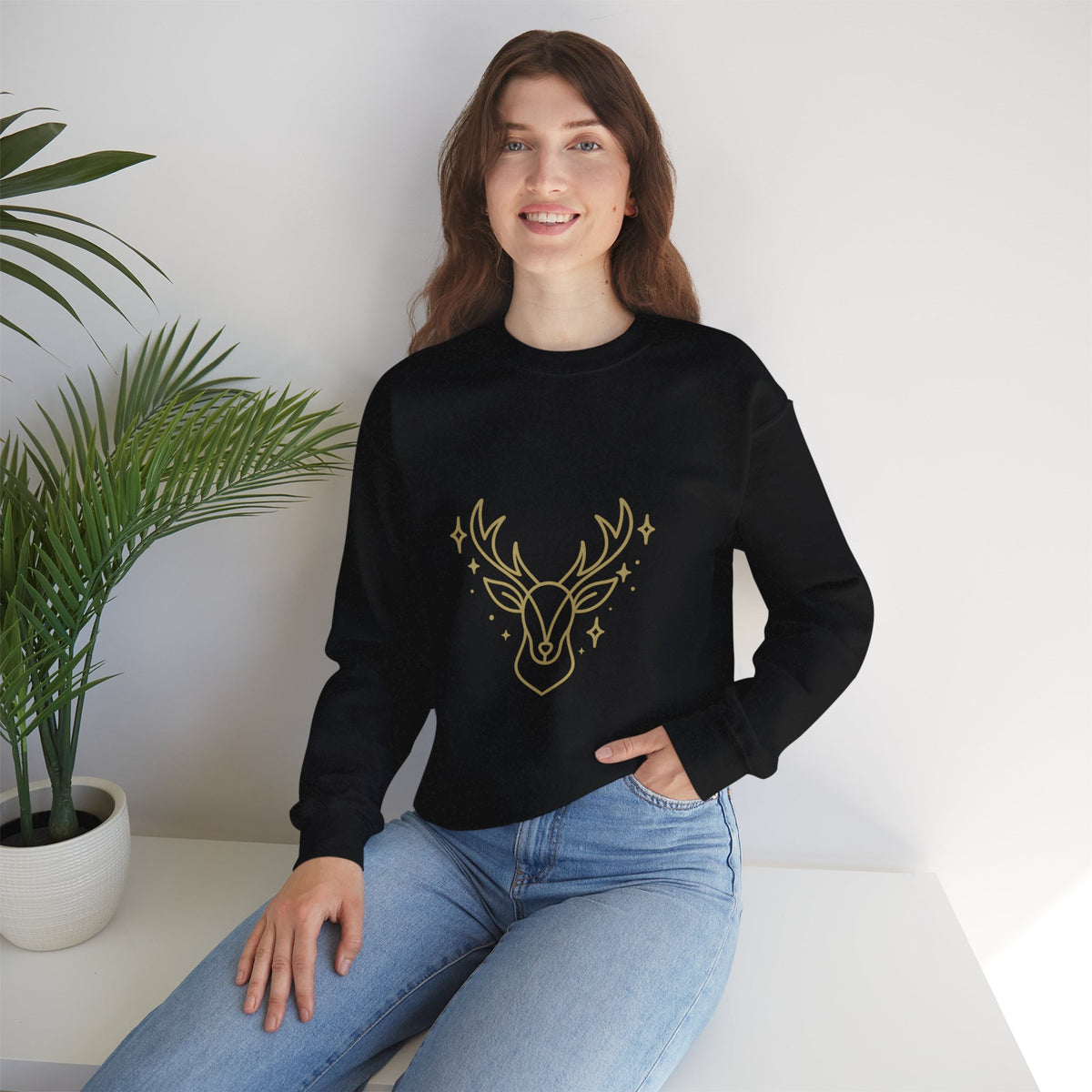 Model wearing a black minimalist gold-colored reindeer sweatshirt