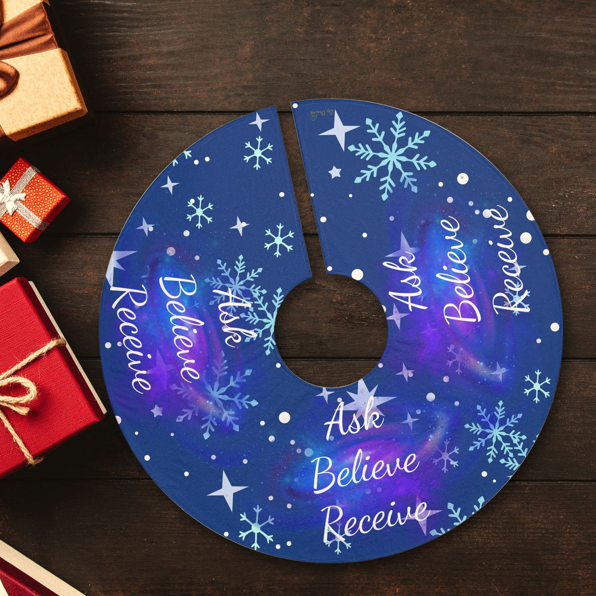 Ask Believe Receive cosmic Christmas tree skirt laid flat with wrapped presents