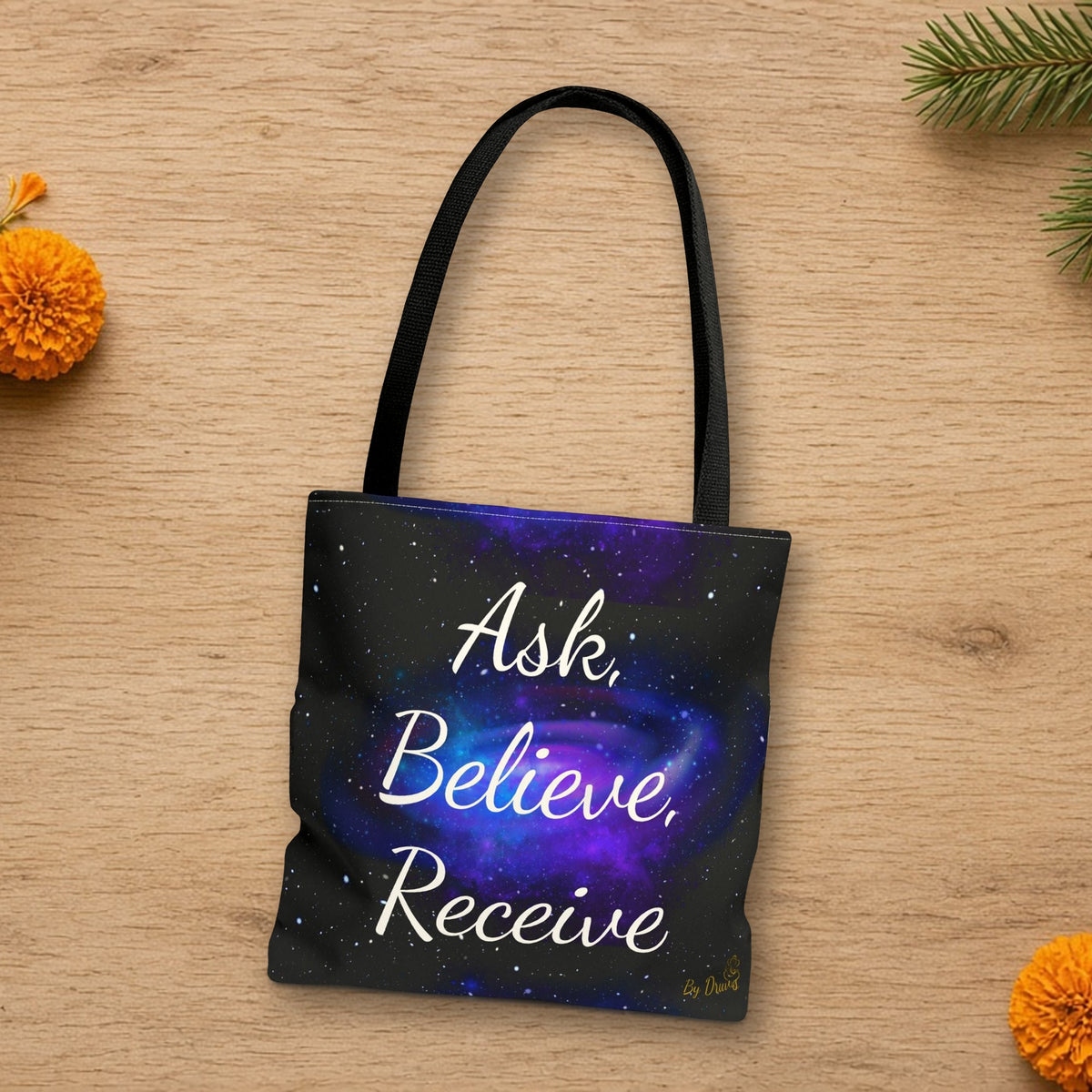 Ask Believe Receive manifestation tote laid flat in a styled lifestyle setting