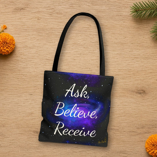 Ask Believe Receive manifestation tote laid flat in a styled lifestyle setting