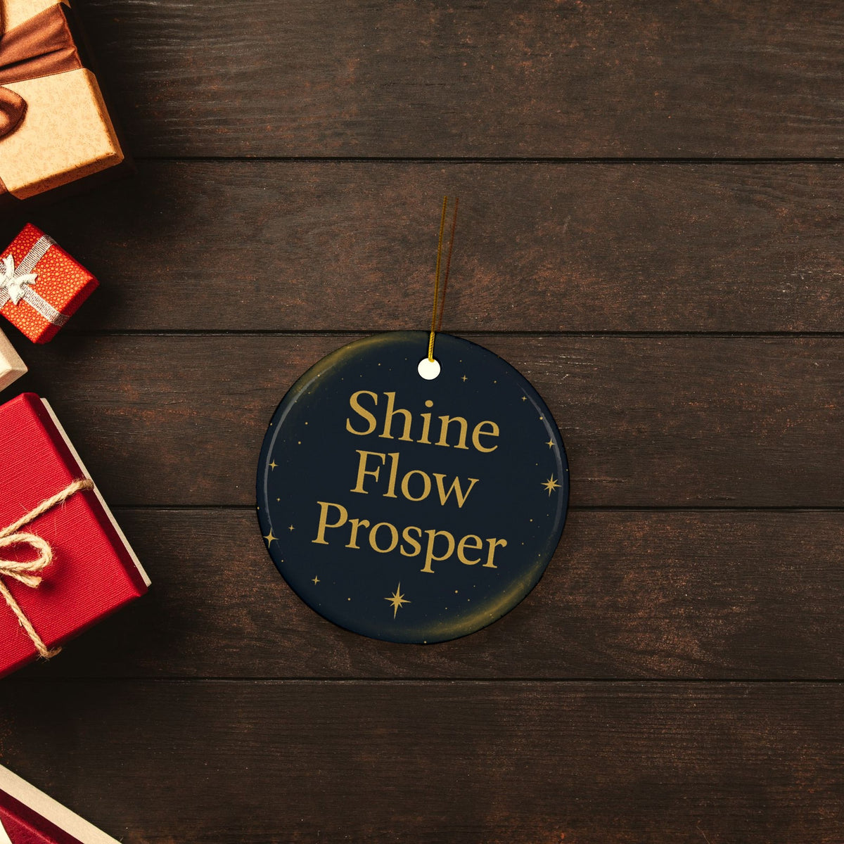 Shine Flow Prosper Ceramic Christmas Ornament in a festive flat lay with wrapped Christmas gifts