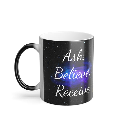 Color-changing ceramic mug with black exterior and hidden purple galaxy design that reveals “Ask. Believe. Receive.” when hot.