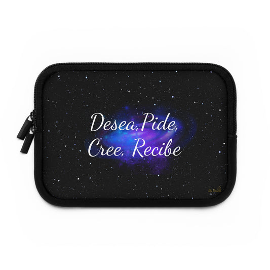 Laptop sleeve with black cosmic background, white Spanish affirmation text “Desea, Pide, Cree, Recibe,” and gold Druvs logo