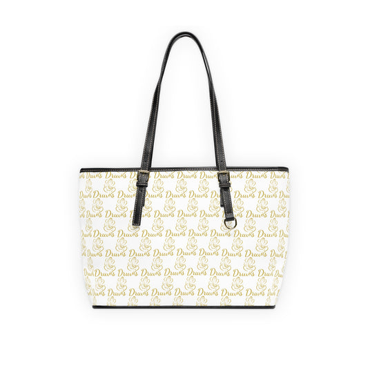 White shoulder bag with gold Druvs and Ganesha logo monogram, black straps, and silver zipper.