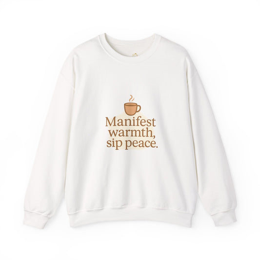 White sweatshirt with warm brown coffee cup graphic and the quote “Manifest warmth, sip peace.” – minimalist winter self-care sweatshirt by Druvs.