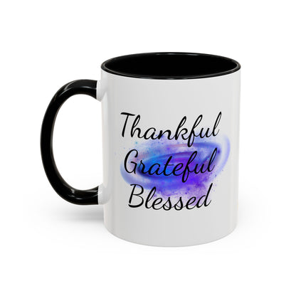 Two-tone white ceramic mug with black handle, featuring “Thankful. Grateful. Blessed.” over a cosmic purple galaxy swirl.