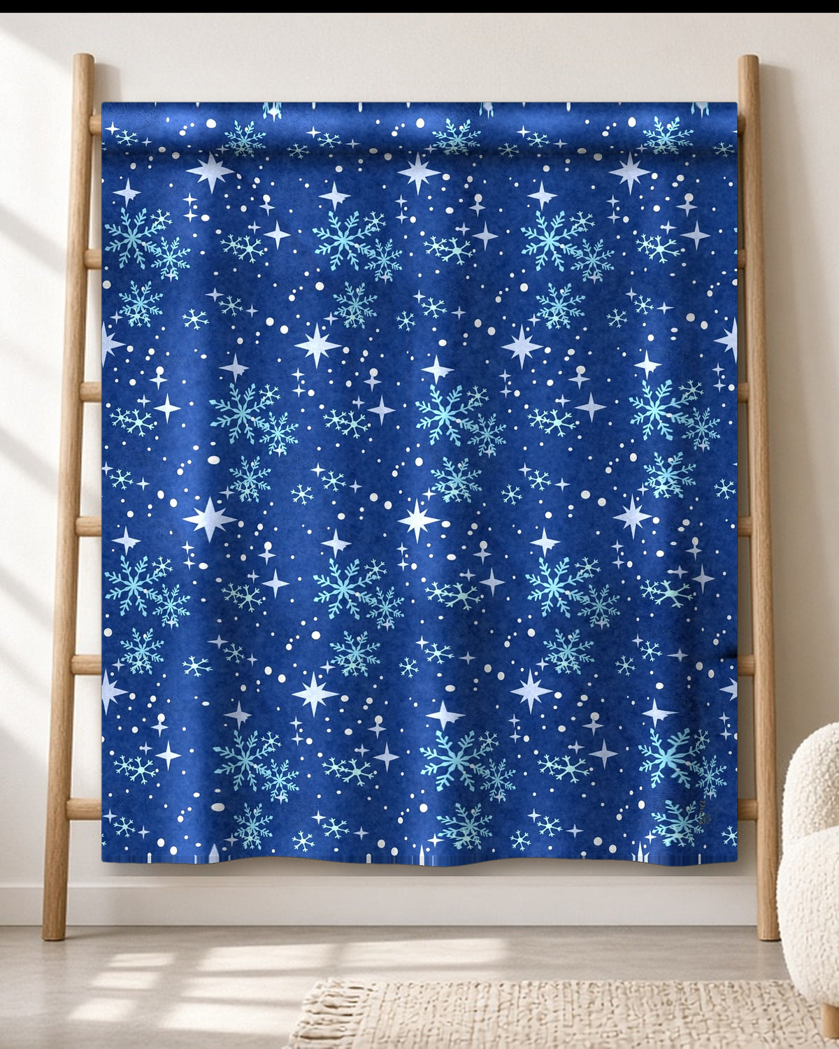 Blue Star & Snowflake winter throw blanket draped on an oak ladder in a bright living room